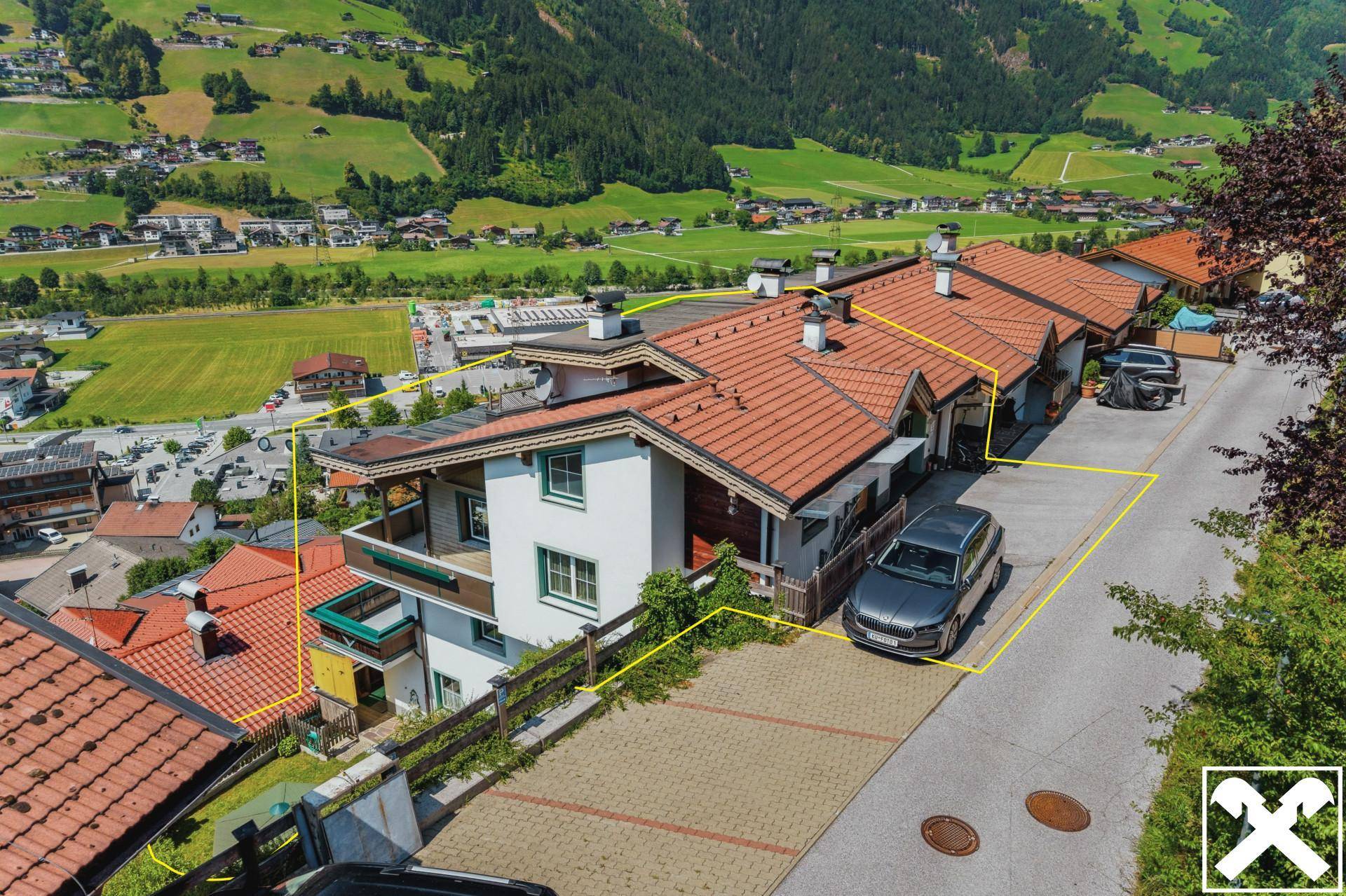 Luftaufnahme des Hauses mit Grundstücksgrenzen, Parkplätzen und Blick auf die Umgebung.