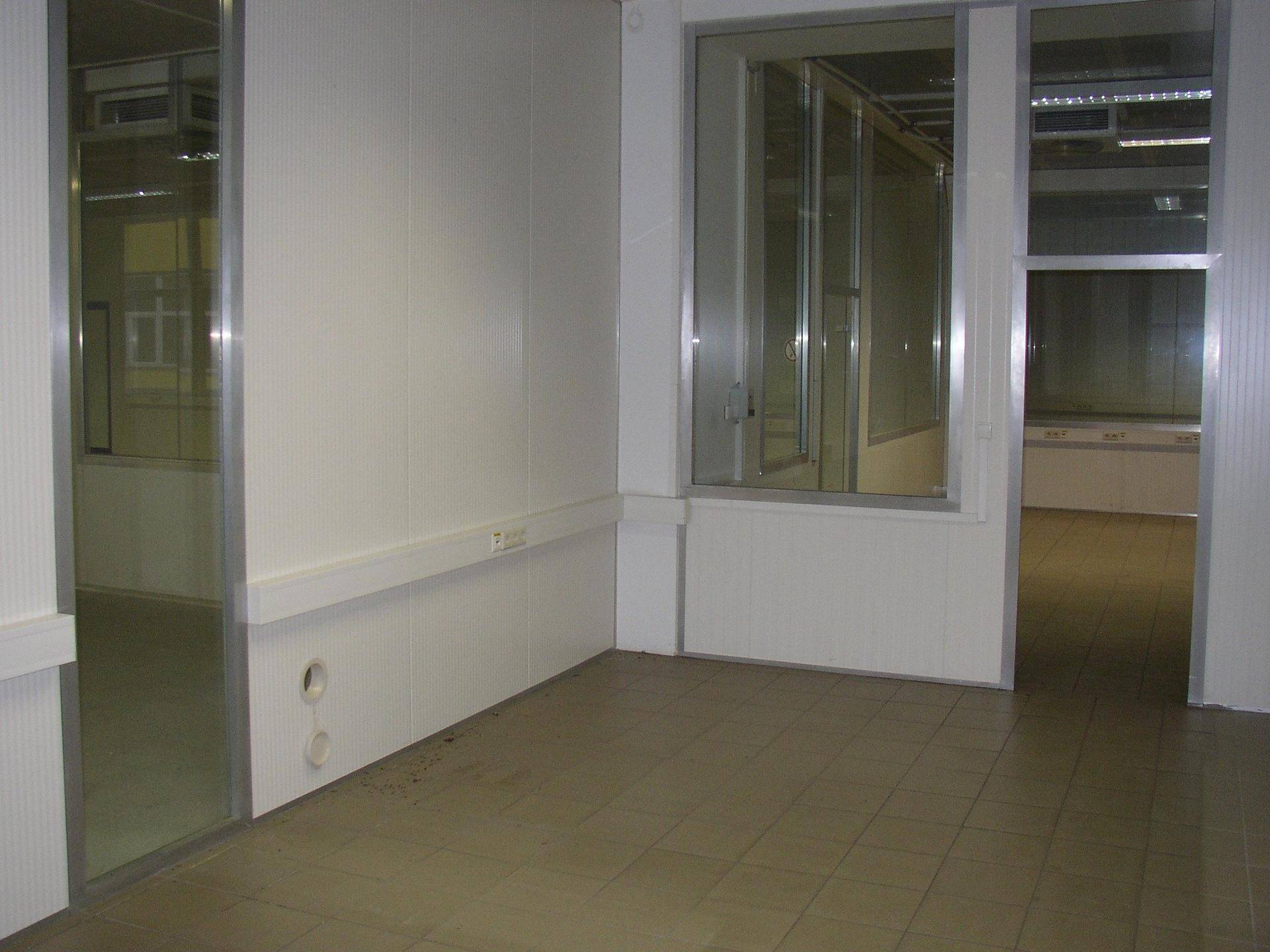 Ecke eines Gewerberaums mit Fliesenboden und modularen Wänden, bereit zur individuellen Gestaltung.