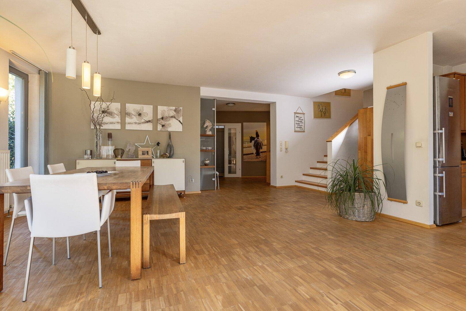 Offener Essbereich mit Holztisch, Parkettboden und Übergang zum Treppenhaus und Wohnbereich.