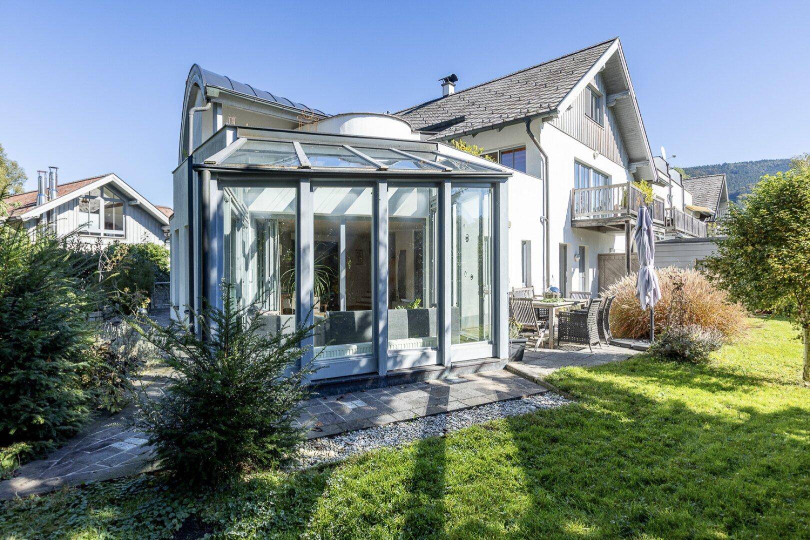Rückseite des Hauses mit Wintergarten, Terrasse und großzügigem Gartenbereich.