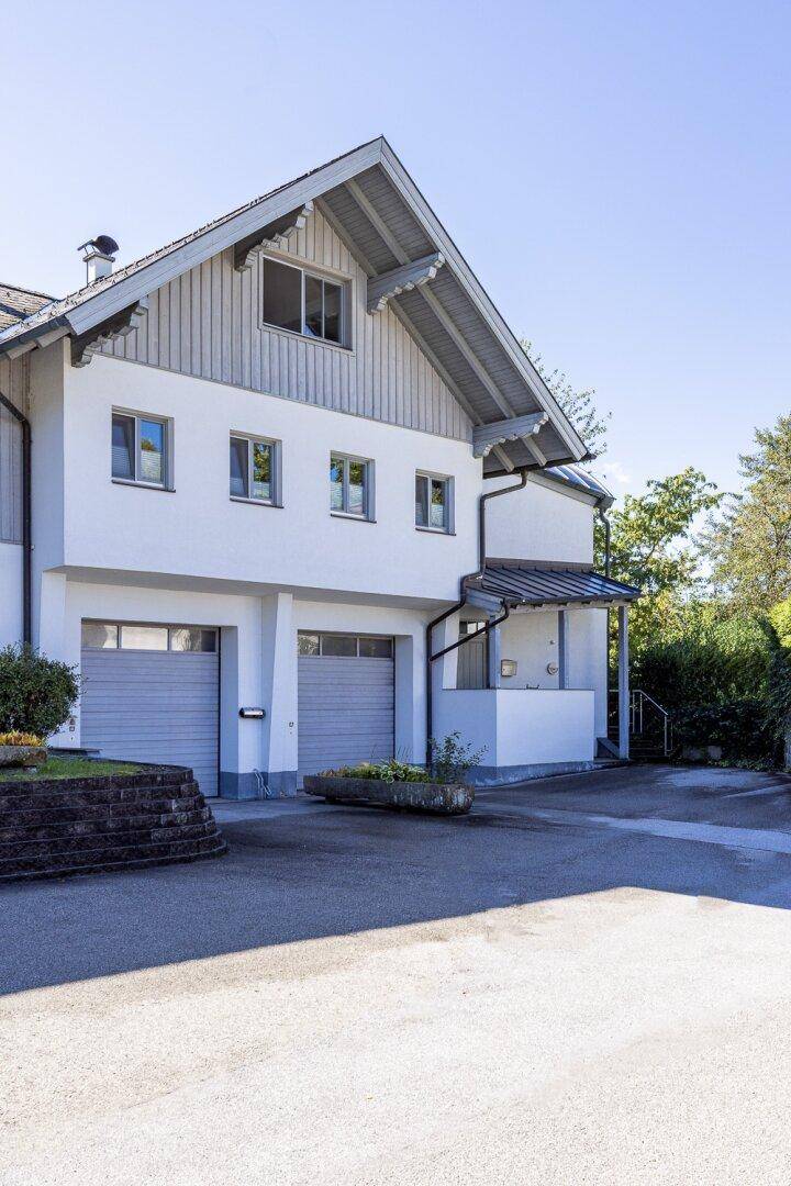 Vorderansicht des Hauses mit zwei Garagen und einem traditionellen Satteldach.