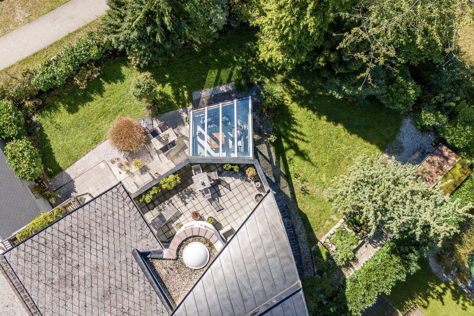 Vogelperspektive des Anwesens mit Dachflächen, großer Terrasse und Wintergarten.