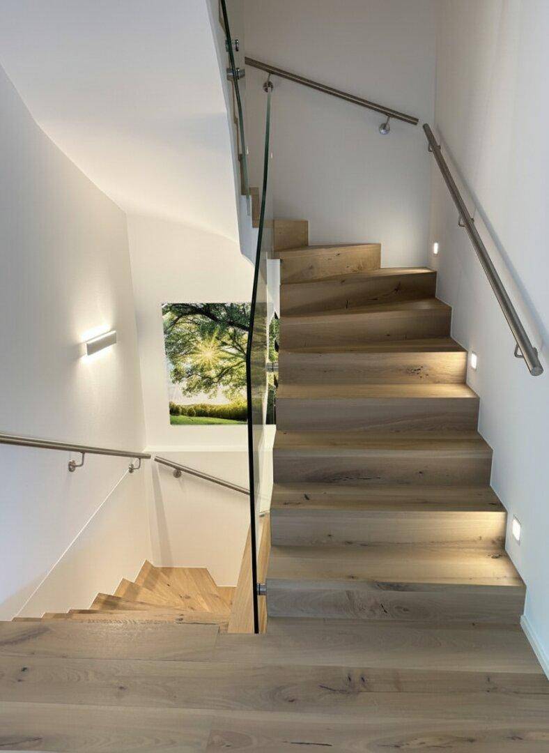 Elegantes Treppenhaus mit Holzstufen, Glasgeländer und indirekter Beleuchtung für eine moderne Atmosphäre.