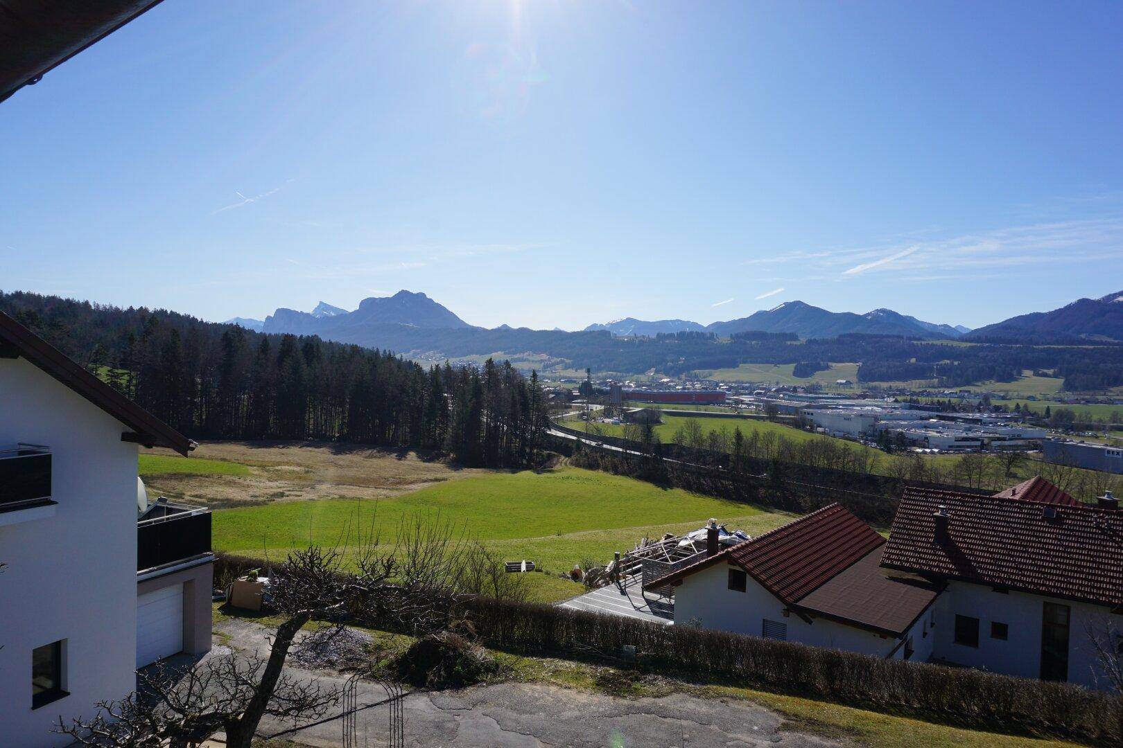 Weitläufiger Ausblick über die ländliche Umgebung mit Feldern, Wäldern und Bergen im Hintergrund.