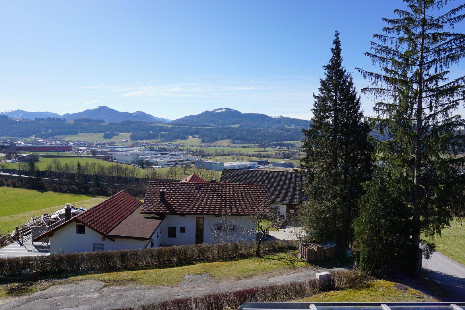 Panoramablick über die ländliche Umgebung mit weiteren Häusern und Bergen im Hintergrund.