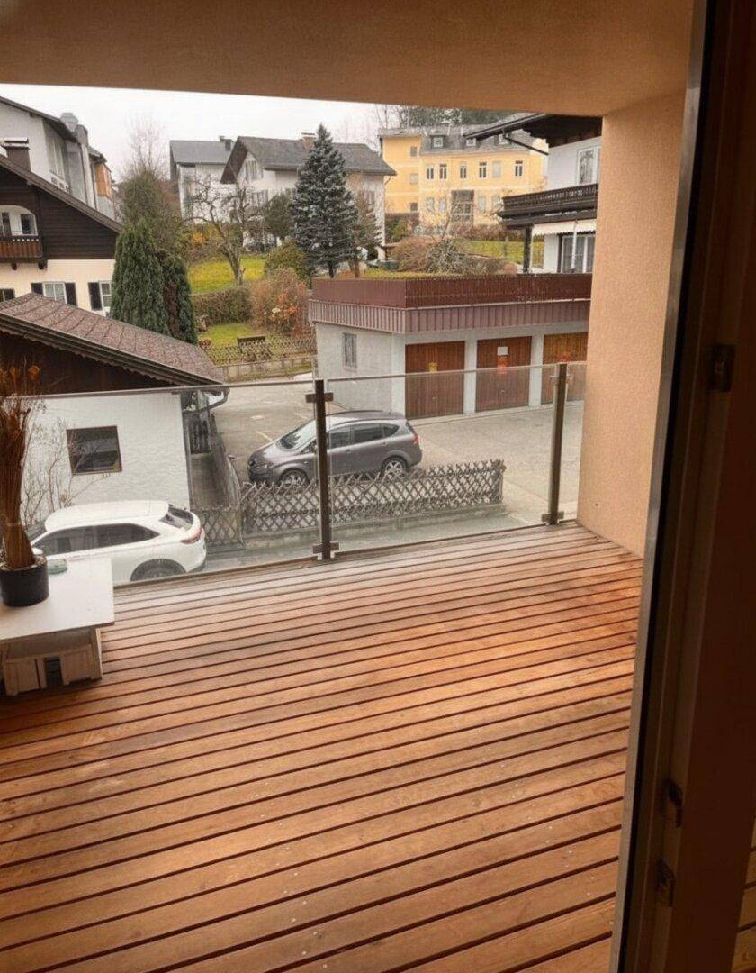 Balkon mit Holzboden und Glasgeländer bietet einen weiten Blick auf die Umgebung.