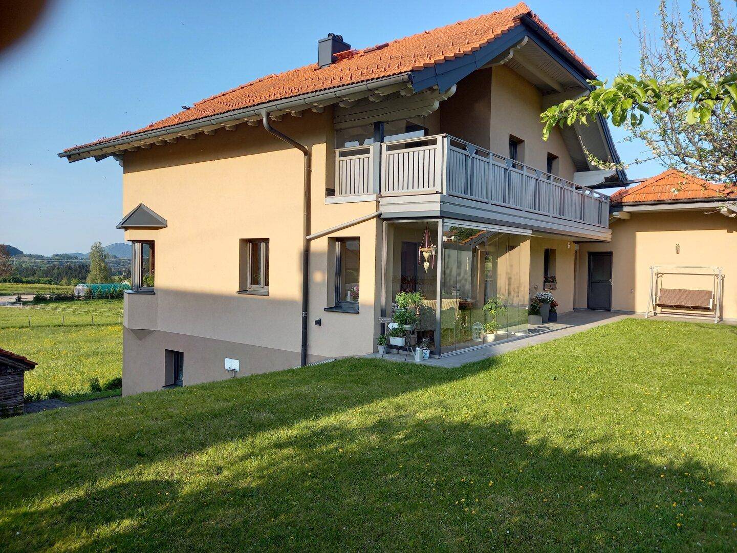 Haus in ländlicher Umgebung mit großem Garten, Balkon und weitem Blick über die Landschaft.