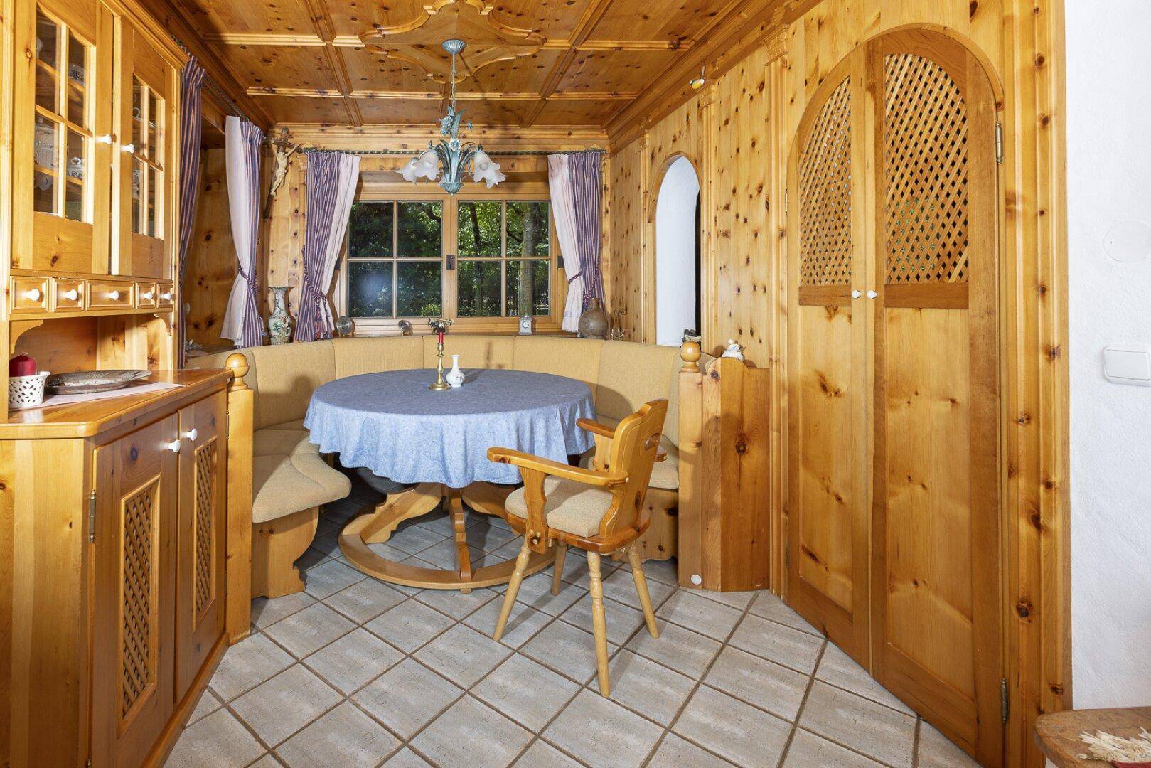 Gemütlicher Essbereich im alpenländischen Stil mit Holztäfelung, Eckbank und traditionellen Möbeln.