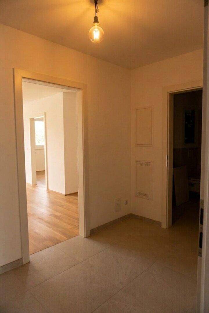 Heller Flurbereich mit Fliesenboden und mehreren Türen, die zu den angrenzenden Räumen führen.