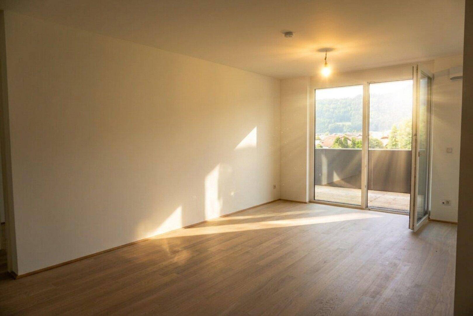 Sonniges Wohnzimmer mit hellem Holzboden und direktem Zugang zum Balkon.