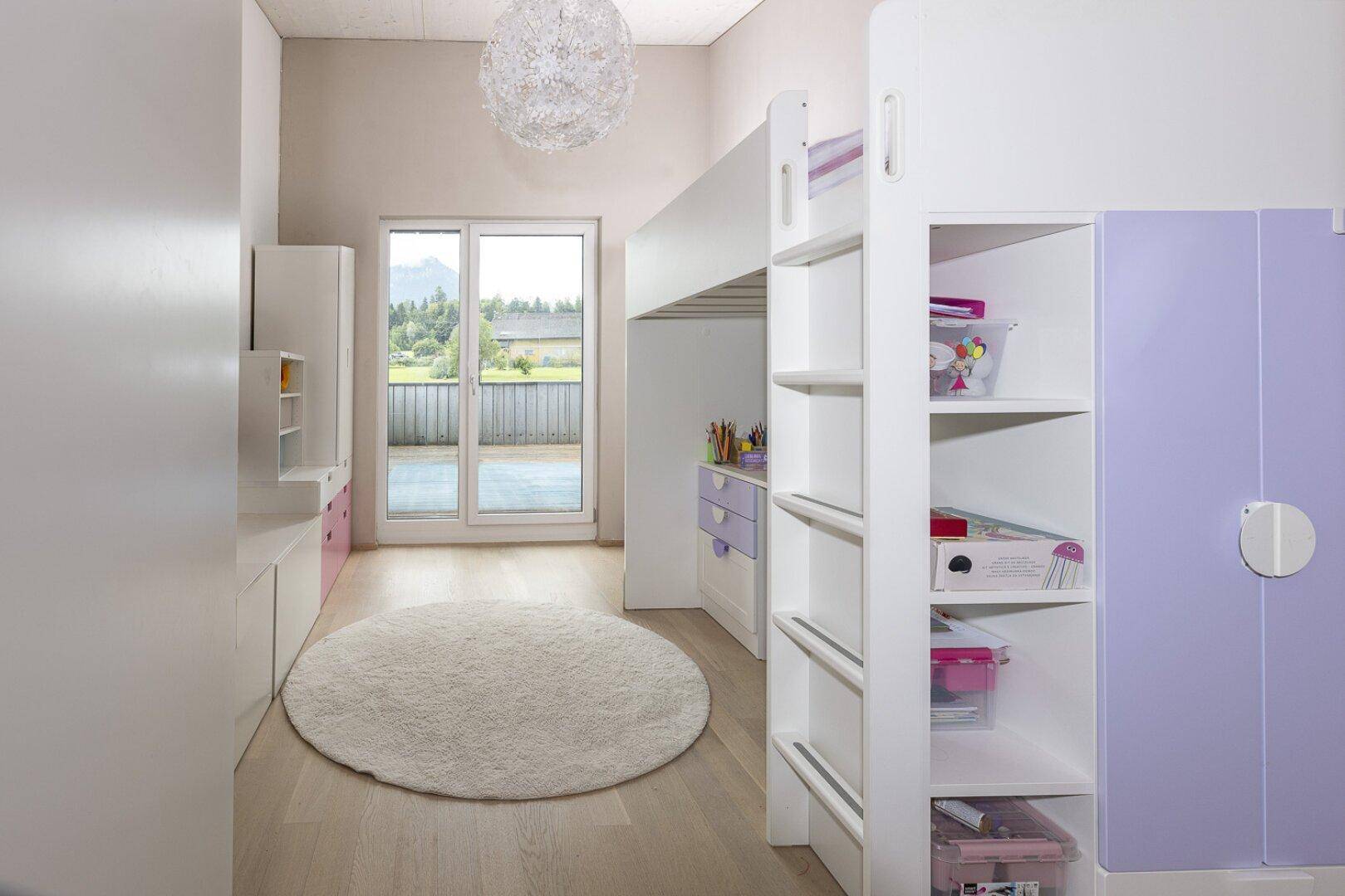 Kinderzimmer mit Hochbett, Schreibtisch und Zugang zu einem Außenbereich.