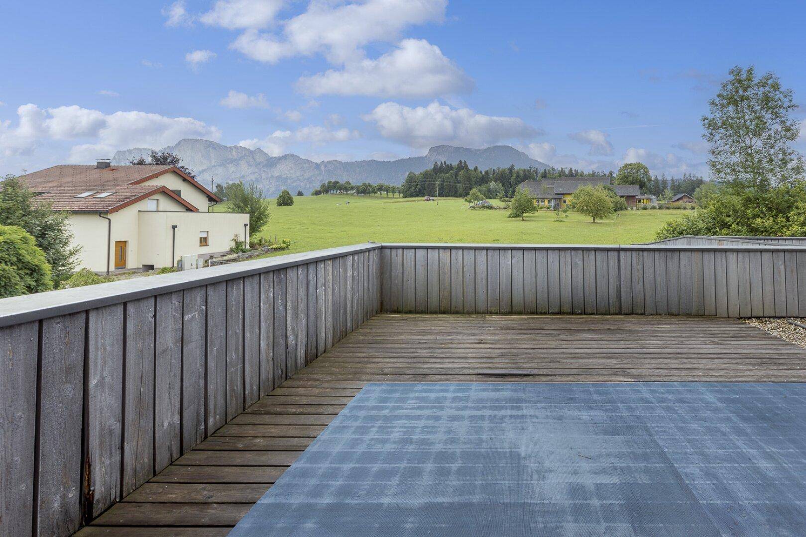 Große Holzterrasse mit weitem Blick auf die umliegende Berglandschaft.