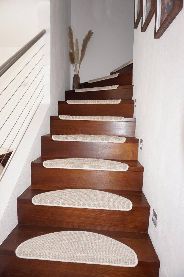 Elegante Holztreppe mit Teppichläufern und modernem Geländer.