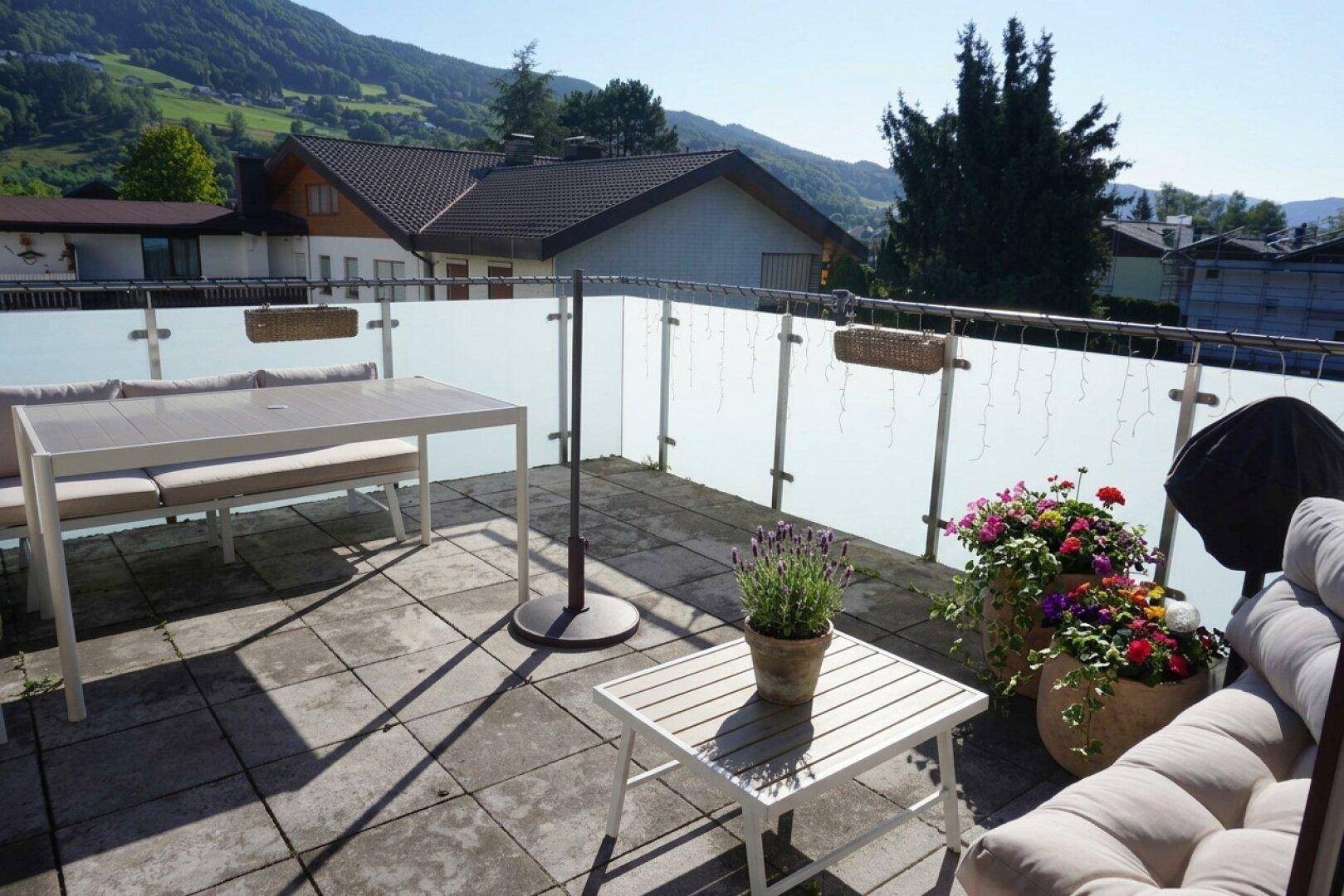 Große Sonnenterrasse mit Sitzgelegenheiten und weitem Blick auf die umliegende Berglandschaft.