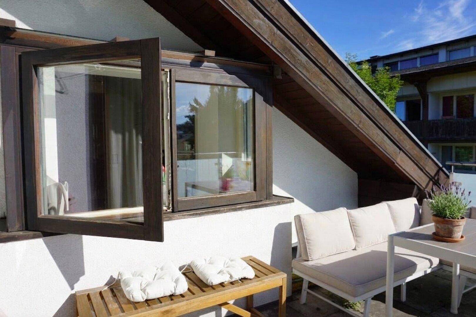 Gemütliche Terrasse mit Sitzbank und Blick auf die umliegende Natur.