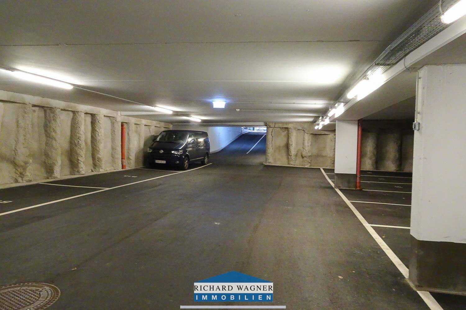 Helle Tiefgarage mit breiten Fahrwegen, ausreichend Parkmöglichkeiten und solider Konstruktion.