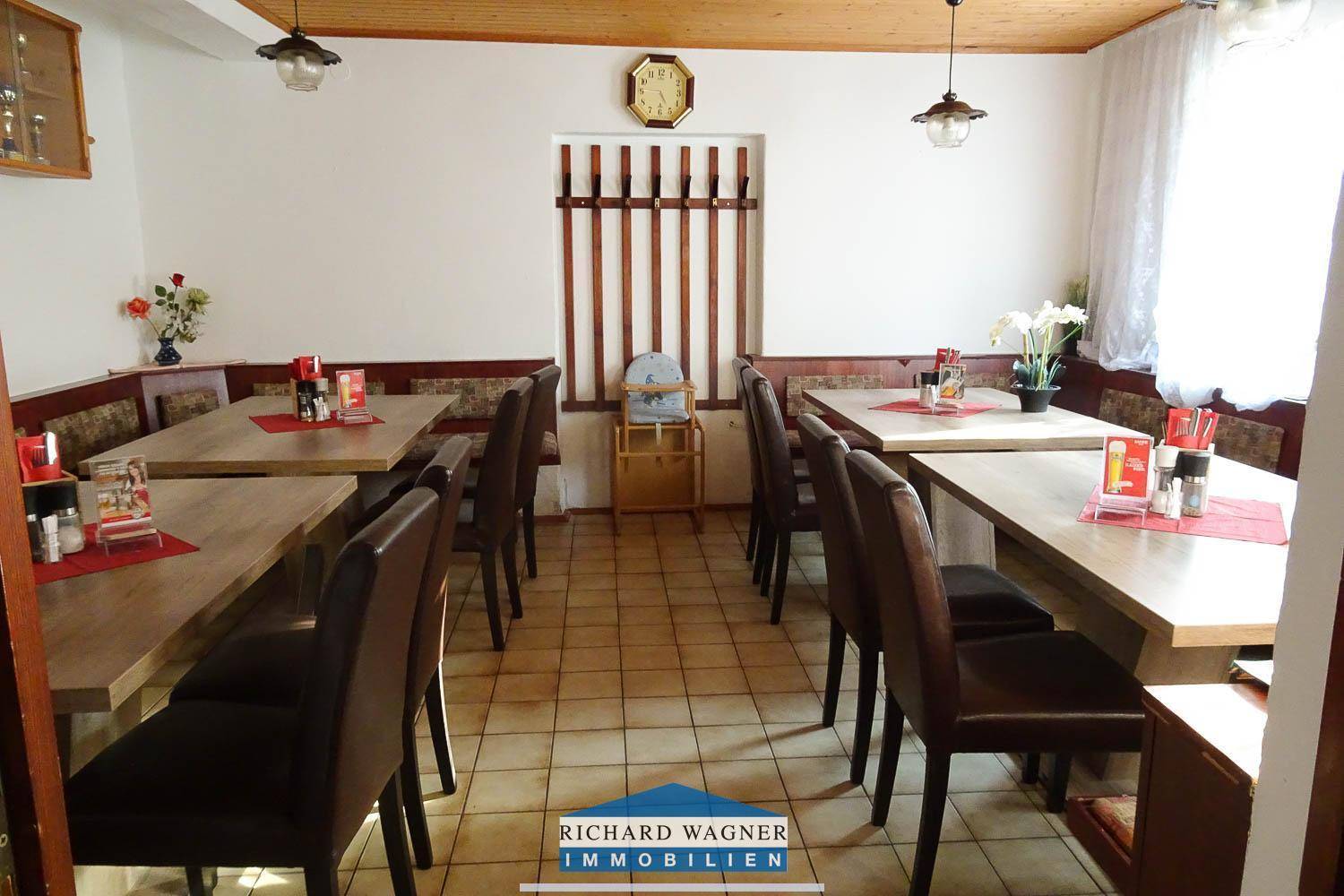 Gemütlicher Speiseraum mit traditionellen Holzbänken, Tischen und Fliesenboden, ideal für kleinere Gruppen.