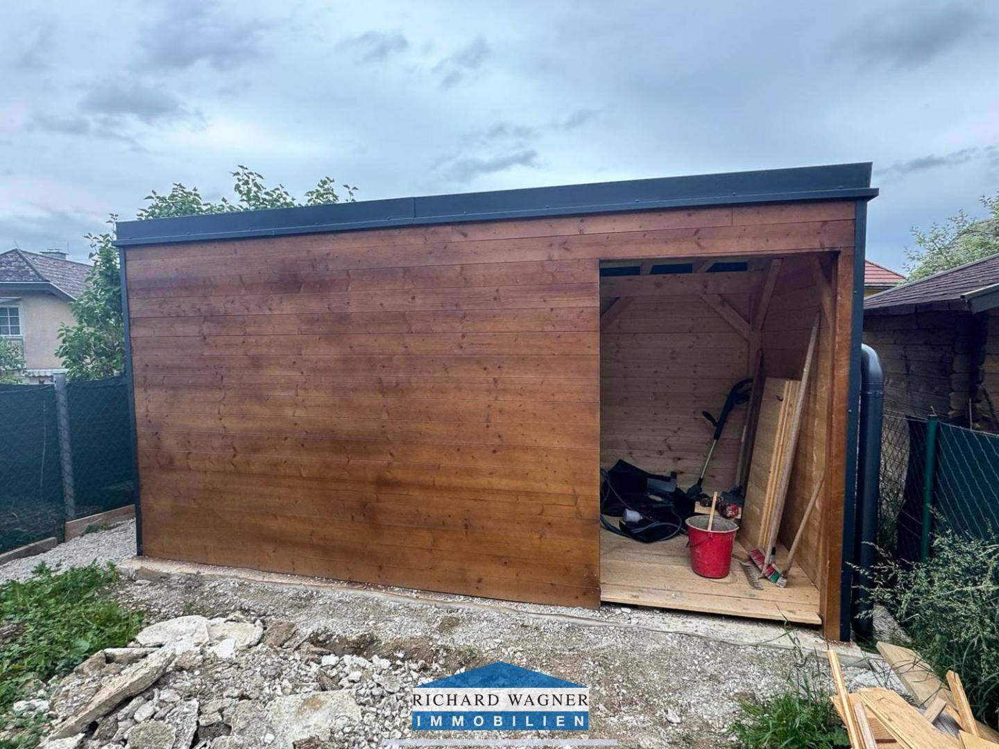 Neu errichteter Holzschuppen im Gartenbereich, ideal als Stauraum für Gartengeräte.