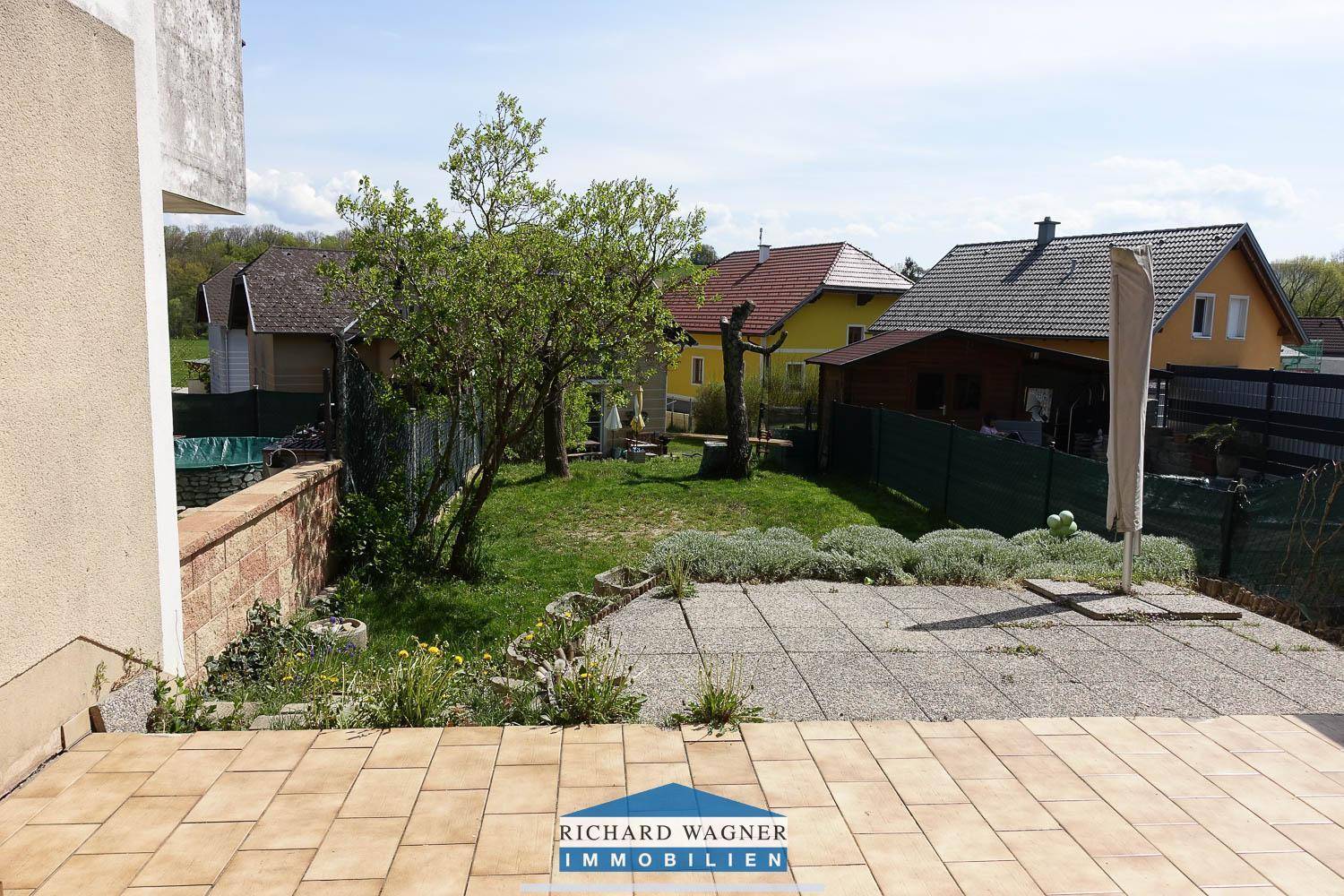 Sonniger Garten mit großer Terrasse und weitem Blick ins Grüne, ideal zum Entspannen.