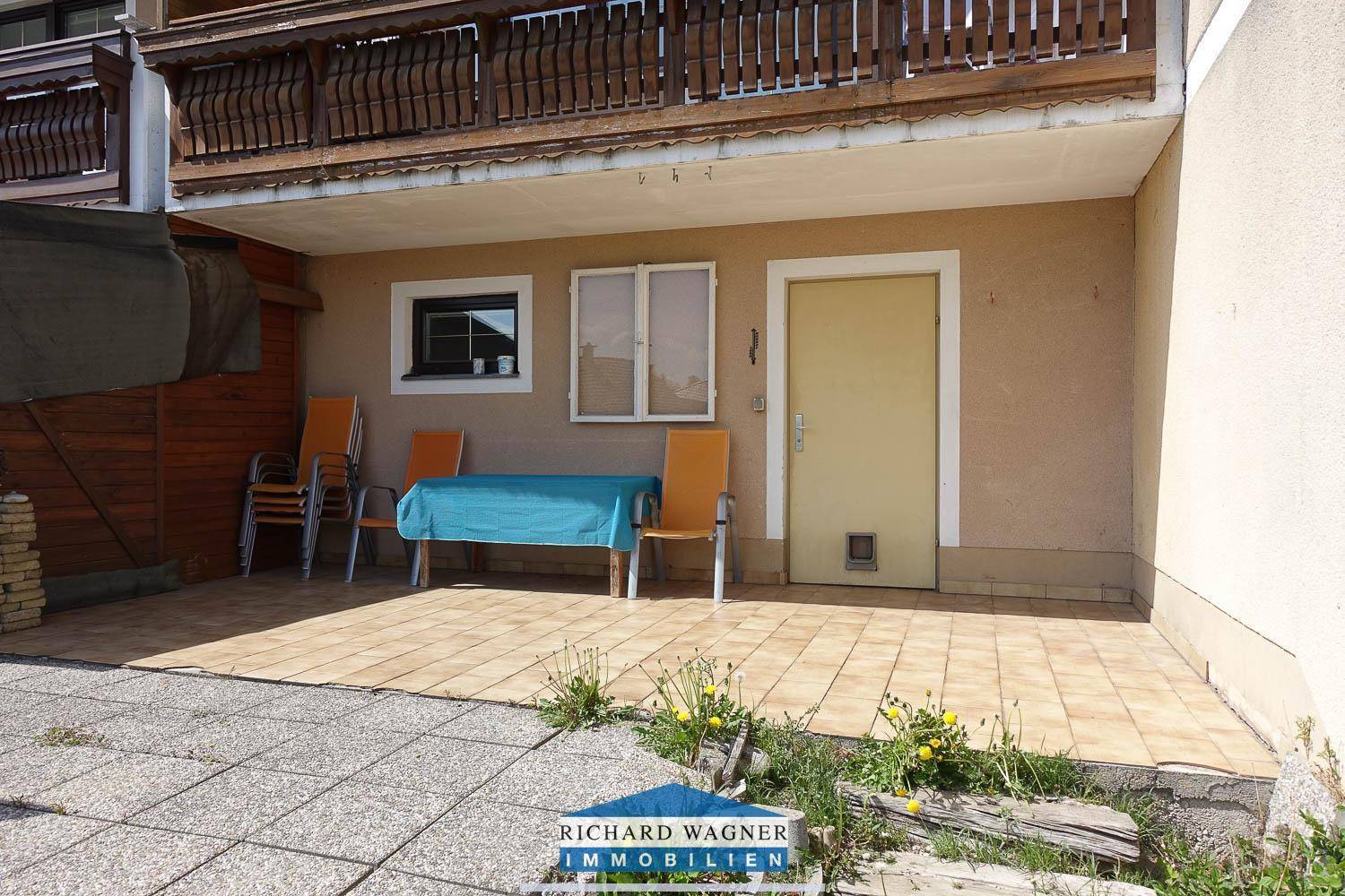 Detailansicht der gefliesten Terrasse mit Sitzgelegenheiten und direktem Zugang zum Garten.