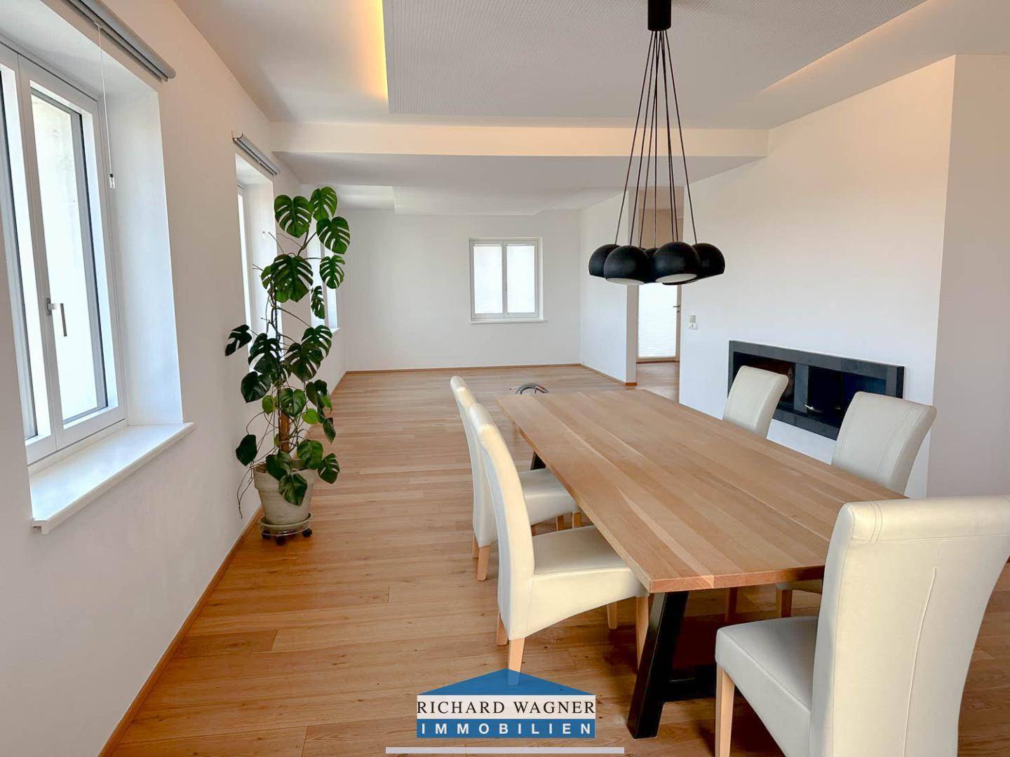 Essbereich mit Holztisch, modernen Stühlen und stilvoller Pendelleuchte im offenen Wohnraum.