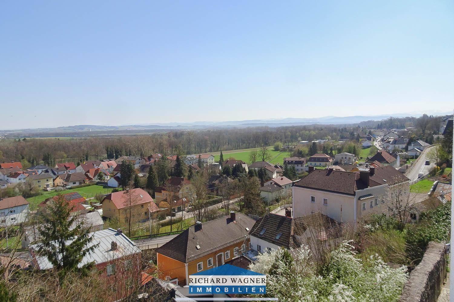 Panoramablick über eine ländliche Siedlung mit vielen Häusern und weiten Feldern.