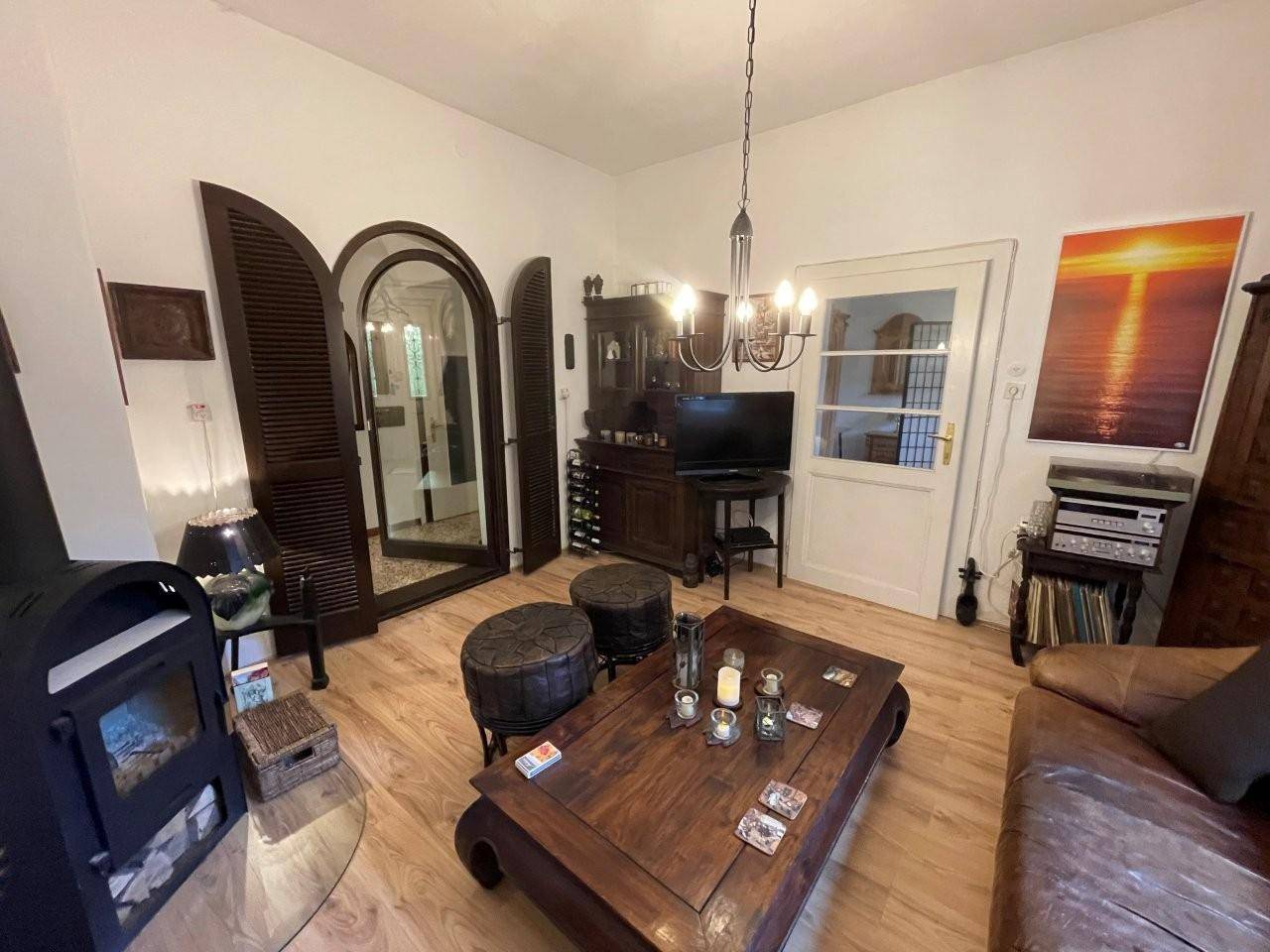 Wohnbereich mit Holzboden, rustikalen Möbeln und Zugang zu einem weiteren Raum.