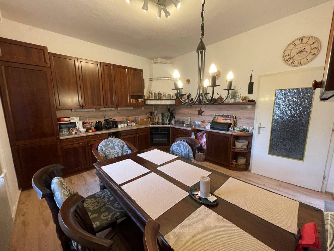 Geräumige Wohnküche mit Holzeinbauten, großem Esstisch und traditionellem Charme.