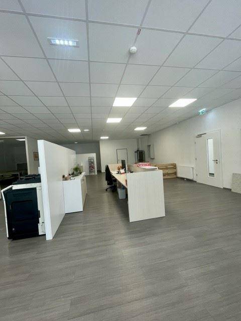 Großzügiger Großraumbüro-Bereich mit mehreren Arbeitsplätzen und modernen Deckenleuchten.