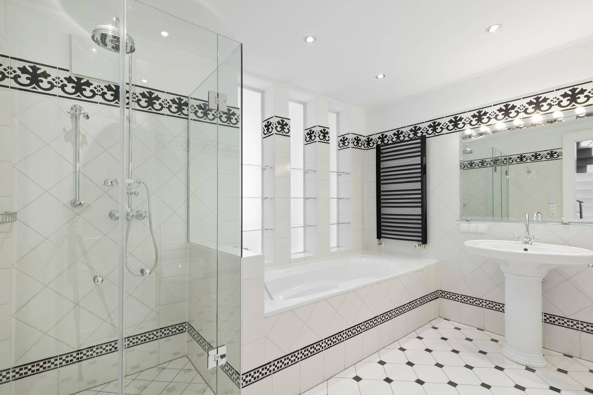 Helles Badezimmer mit großer Dusche, Badewanne und stilvollen Fliesen.