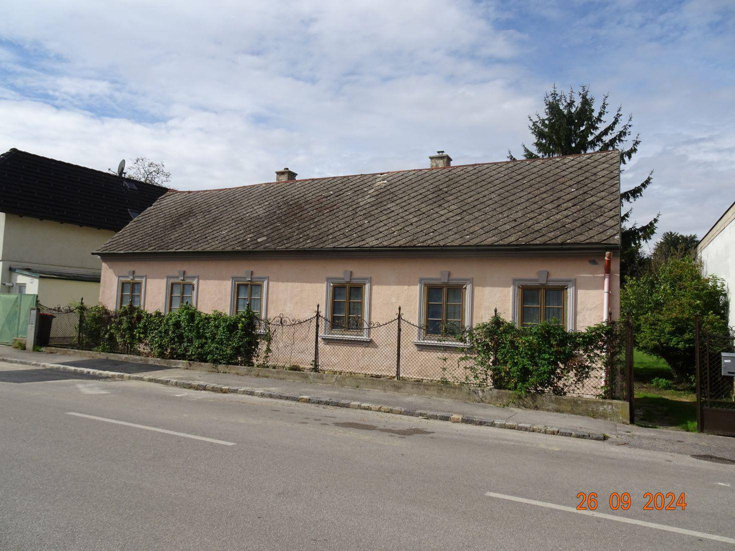 Ansicht des Einfamilienhauses von der Straße mit gepflegter Fassade und Vorgarten.