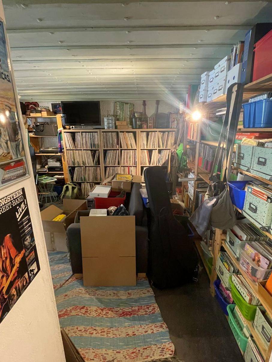 Geräumiger Abstellraum oder Hobbyraum mit Regalen voller Schallplatten und Büchern.