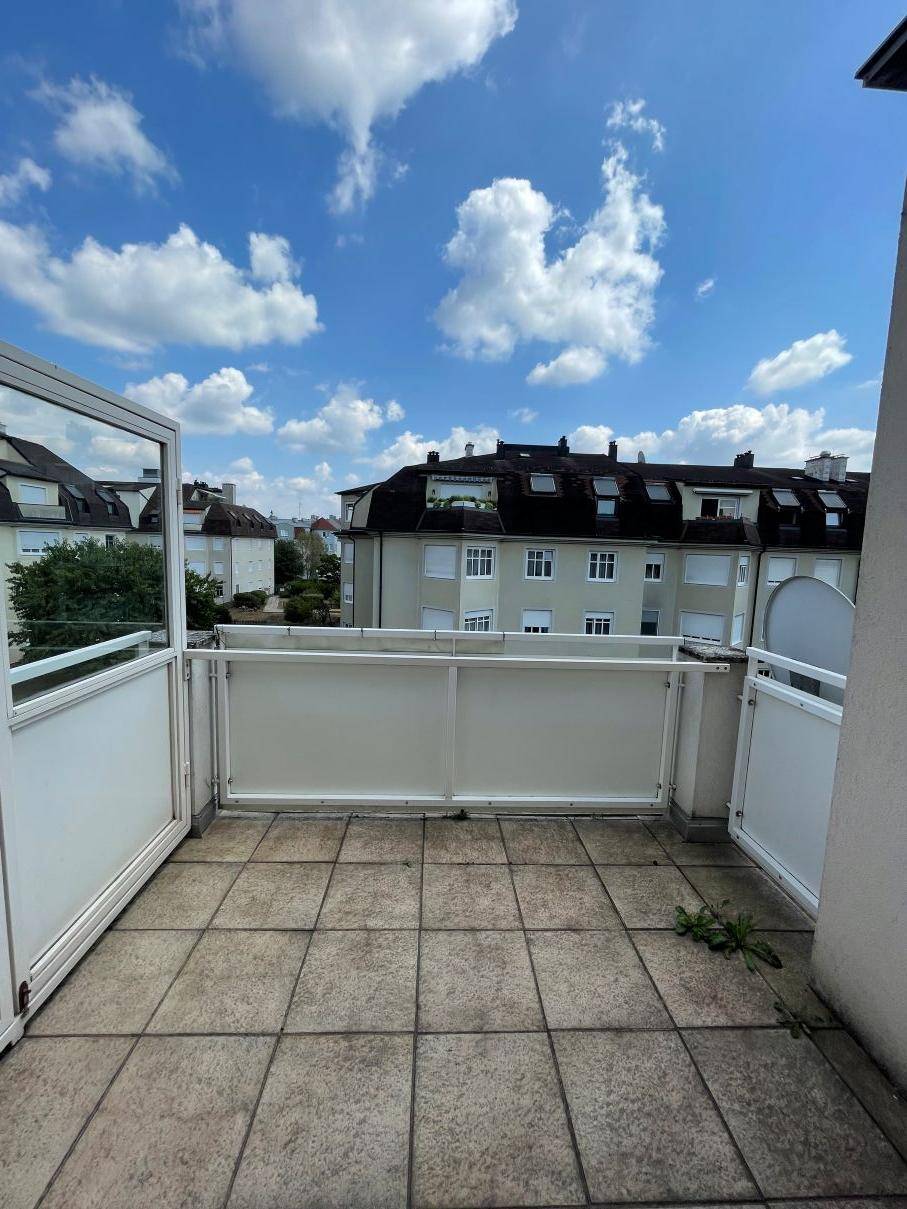 Geräumiger Balkon mit Fliesenboden und weitem Blick auf die Nachbarschaft.