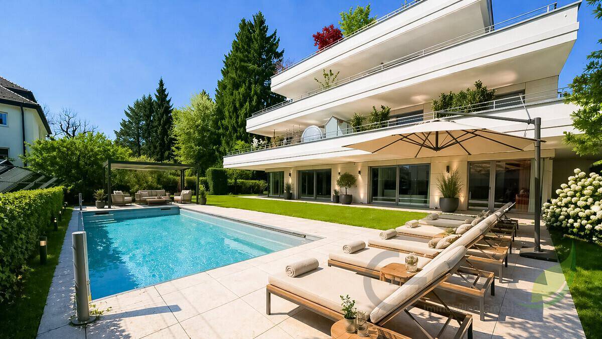 Sonniger Außenbereich mit großem Pool, Liegestühlen und moderner Architektur im Hintergrund.