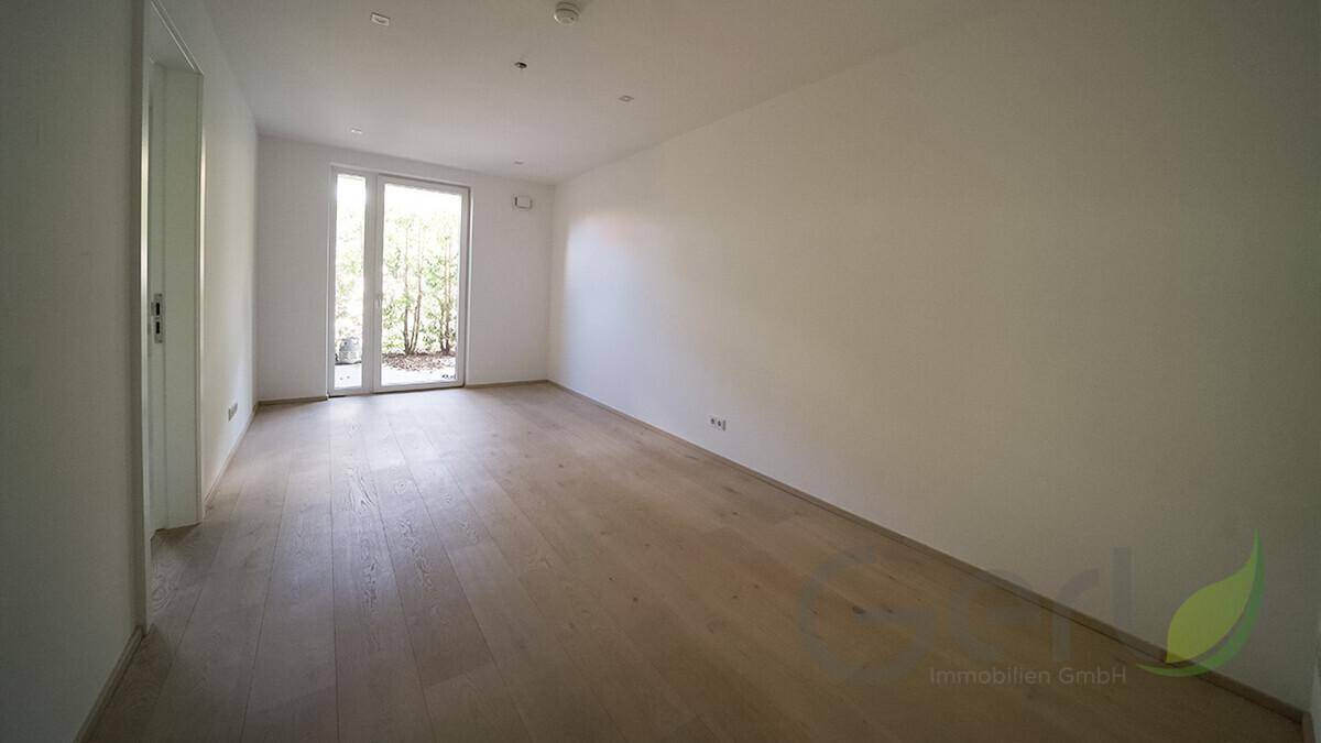 Leeres Zimmer mit Holzboden und Zugang zum Außenbereich, ideal für individuelle Nutzung.