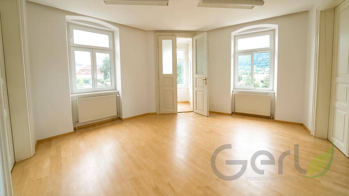 Helles Büro mit modernem Schreibtisch, ergonomischem Stuhl und gemütlicher Sitzecke, ideal für produktives Arbeiten.