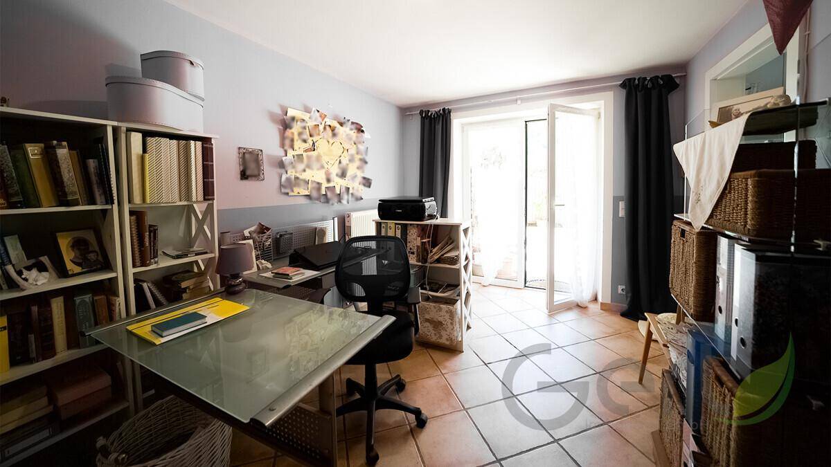 Geräumiges Büro mit Schreibtisch, Bücherregalen und Zugang zu einem Außenbereich.