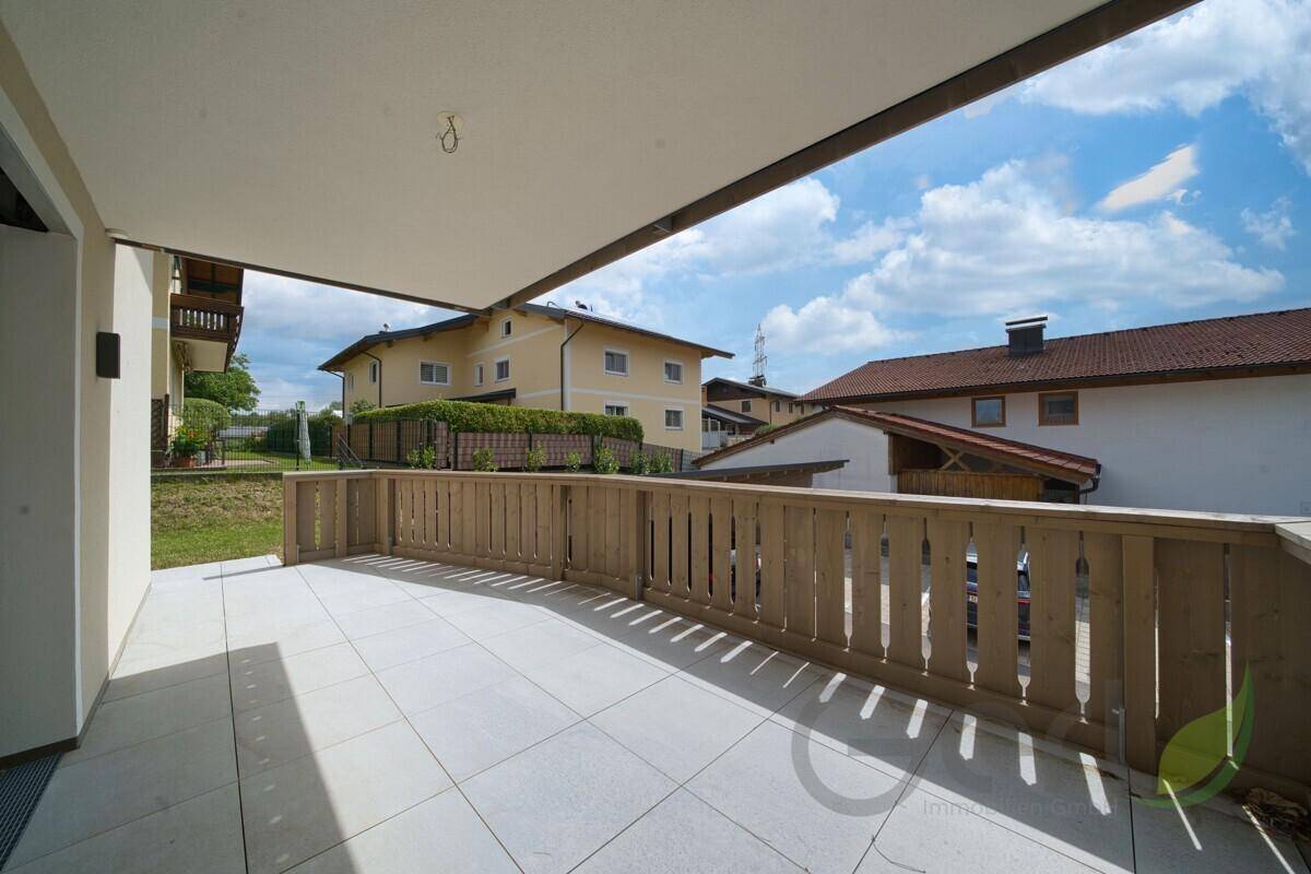 Große, unmöblierte Terrasse mit Fliesenboden und Holzgeländer, ideal für individuelle Gestaltung.