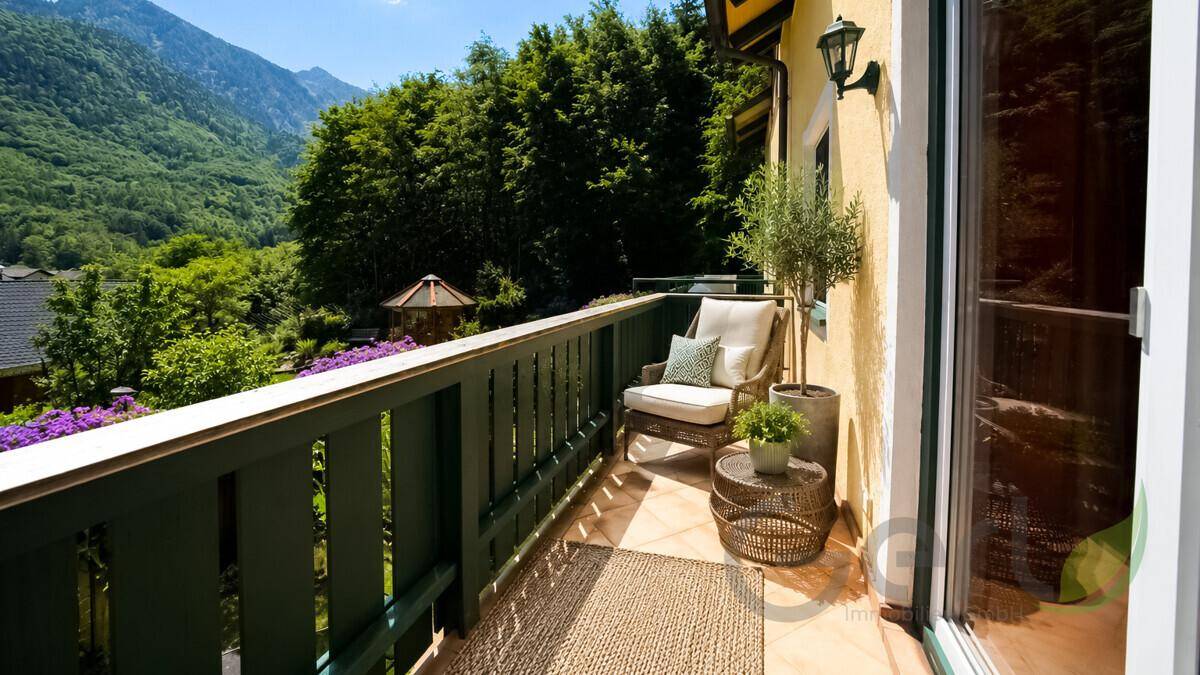 Sonniger Balkon mit Sitzgelegenheit und herrlichem Blick auf die umliegende Berglandschaft.