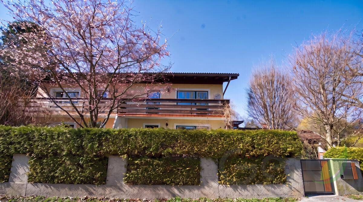 Ansicht des Hauses von der Straße mit gepflegter Hecke und Balkon im Obergeschoss.