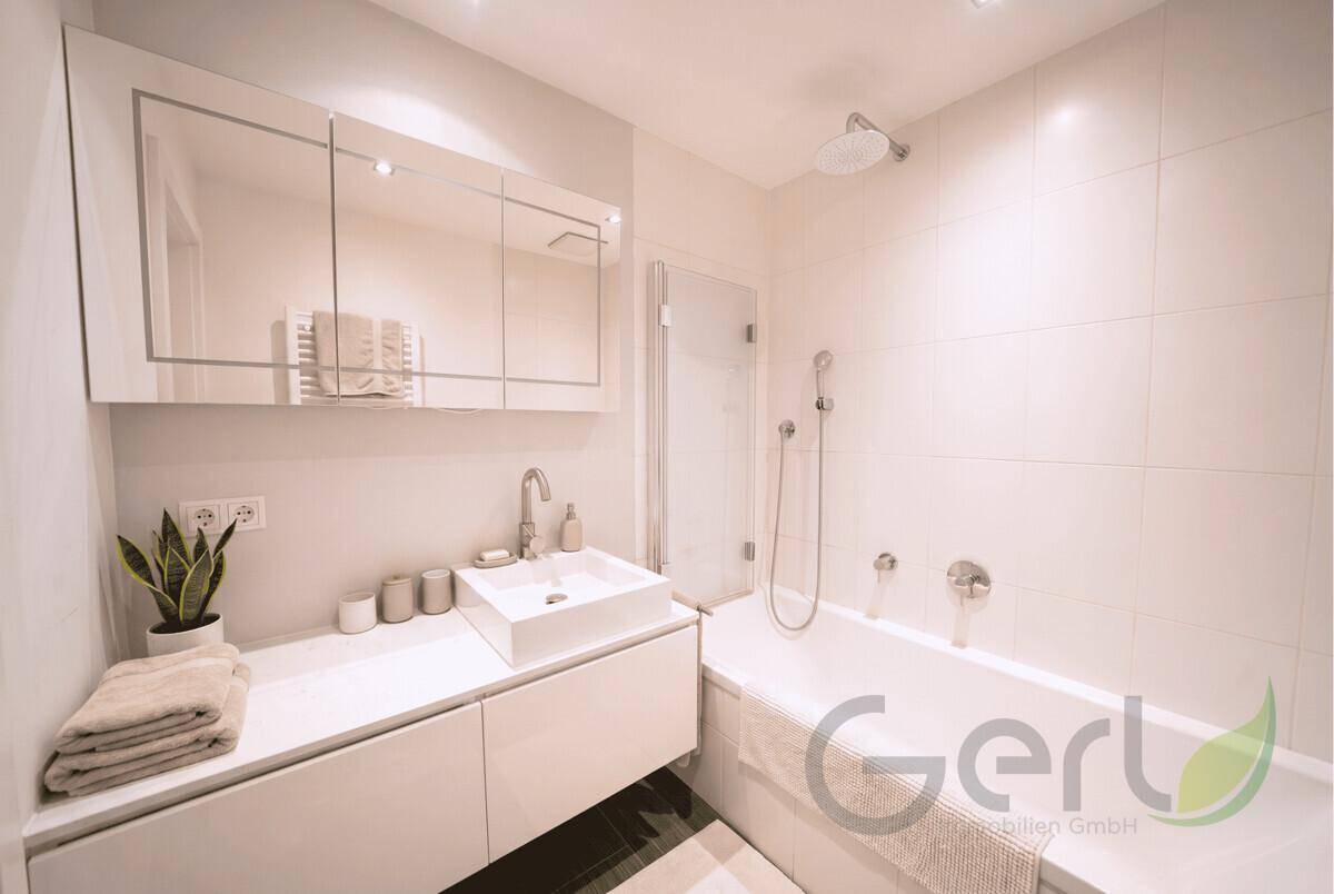 Modernes Badezimmer mit Badewanne, Dusche, Einzelwaschbecken und Spiegelschrank.
