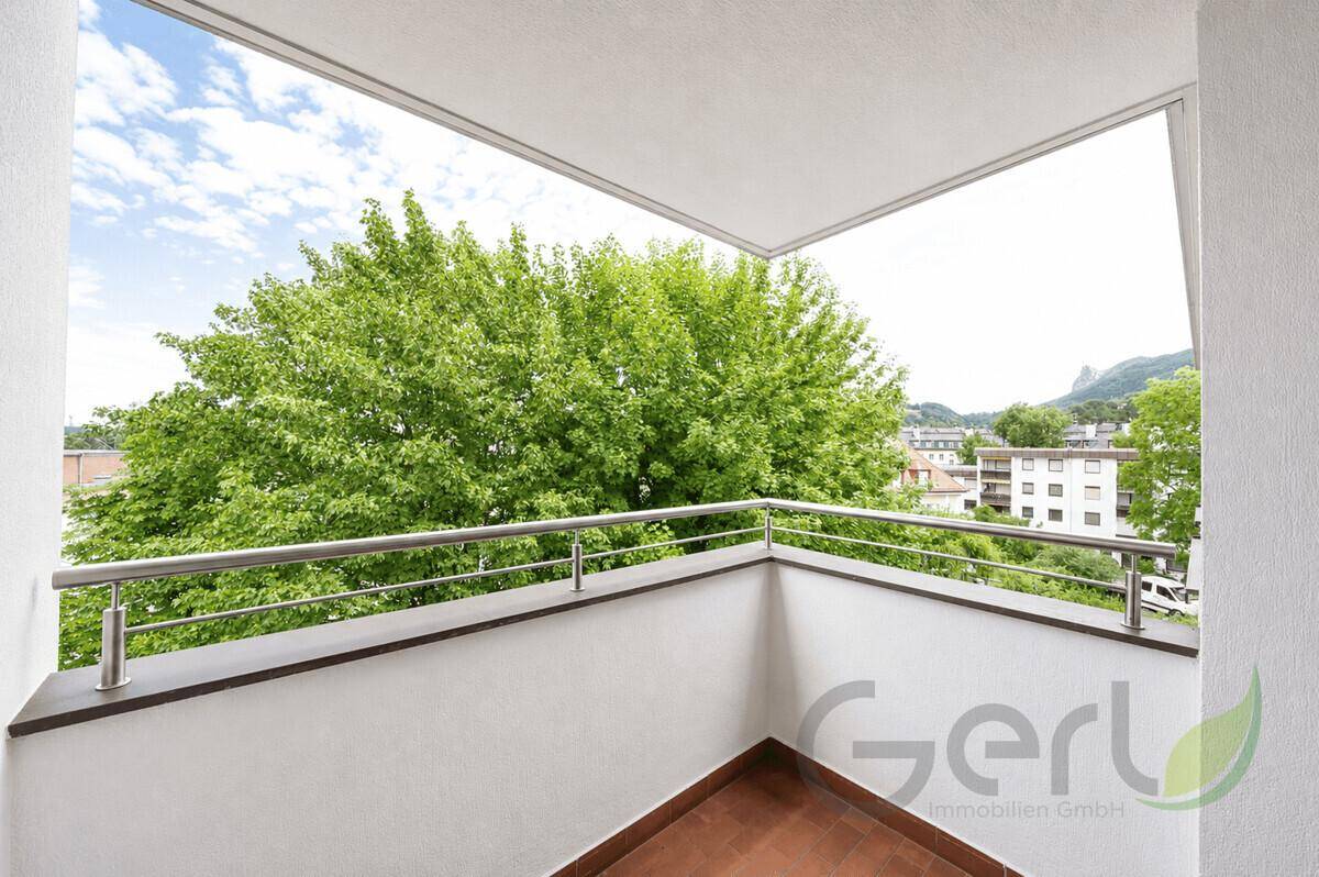 Heller Balkon mit Metallgeländer und weitem Blick ins Grüne und auf die Umgebung.