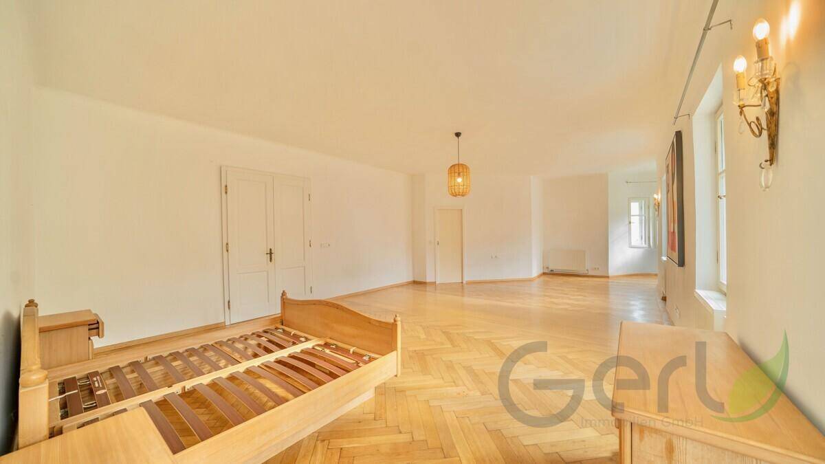 Helles Schlafzimmer mit Fischgrätparkett, hohen Decken und viel Platz.