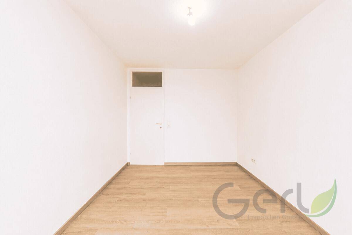 Helles Zimmer mit Laminatboden und weiß gestrichenen Wänden, bereit zur individuellen Gestaltung.