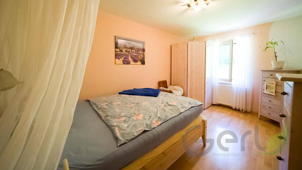 Freundliches Schlafzimmer mit Einzelbett, hellem Holzschrank und Fenster für natürliche Belichtung.