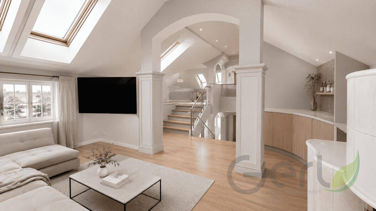 Modernes Wohnzimmer im Dachgeschoss mit hohen Decken, Dachfenstern und offener Treppe zum Obergeschoss.