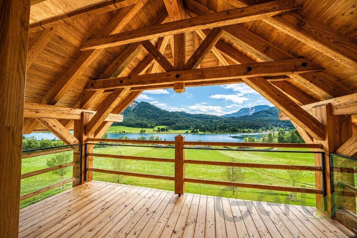 Großer Holzbalkon mit beeindruckendem Blick auf den See und die umliegenden Berge.