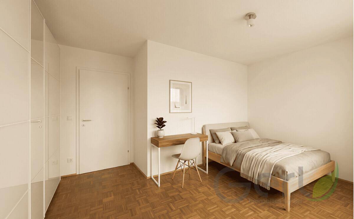Schlichtes Schlafzimmer mit Einzelbett, Schreibtisch und großem Kleiderschrank.