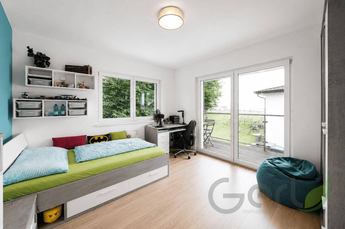 Jugendzimmer mit Bett, Schreibtisch und direktem Zugang zum Balkon.