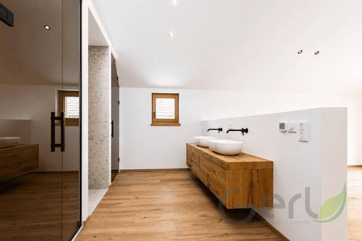 Modernes Badezimmer im Bau mit Doppelwaschbecken und Holzelementen unter Dachschrägen.